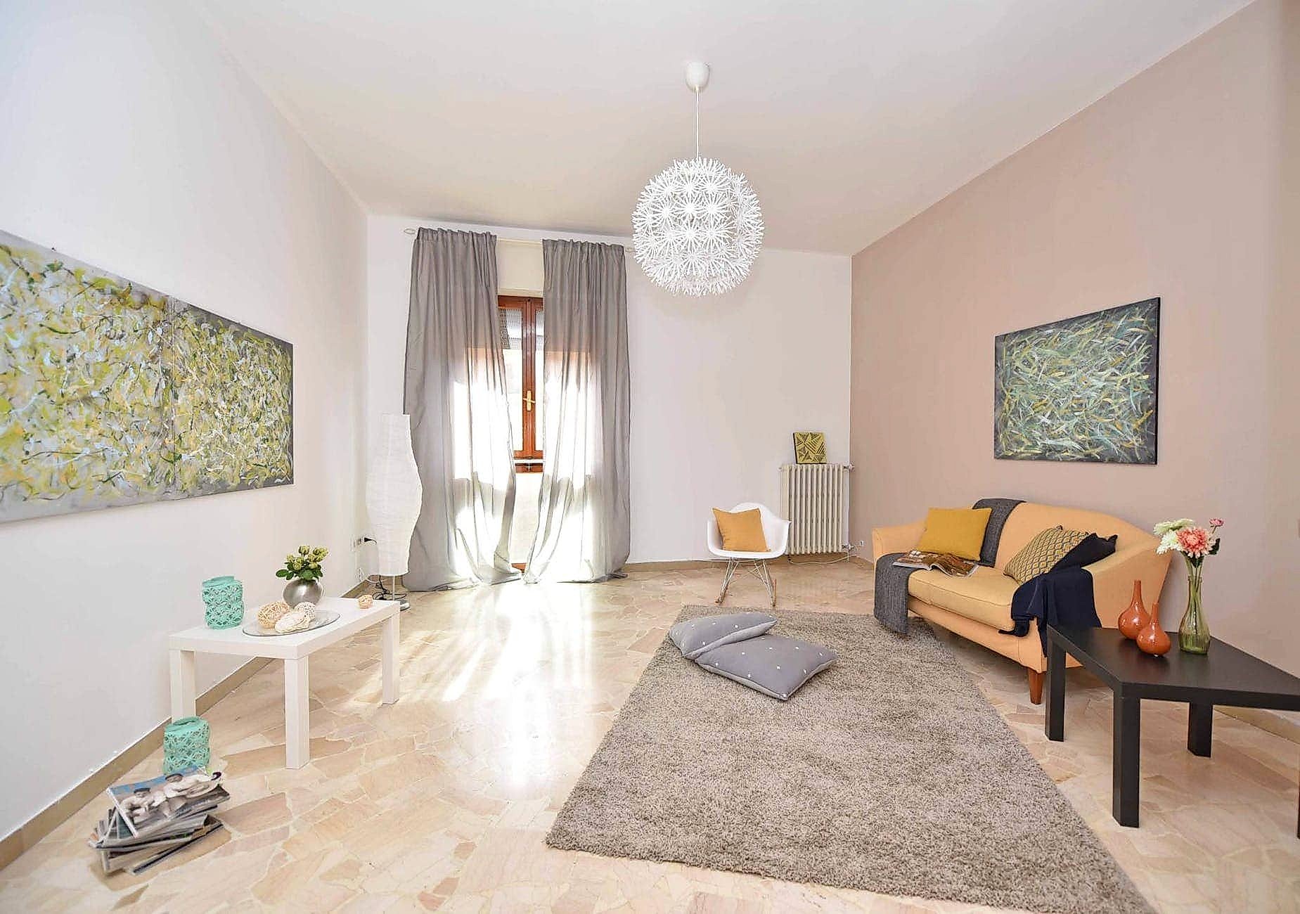 Living room with orange couch and gray rug